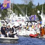 Members of an ambassador crew greet the crowd gathered on one of the log booms before the start of the 2015 Windermere Cup Saturday. -Source: John Lok/The Seattle Times